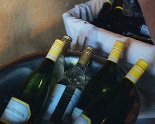 Flessen wijn liggend in wijnkoeler